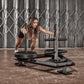 An athlete pushing a prowler sled filled with bumper plates.